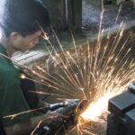 A worker with very little protective gear working in Yangon’s South Dagon Industrial estate - photo: David Browne