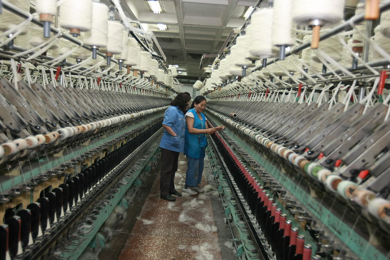 Industrial looms are operated at a rug factory. © ILO